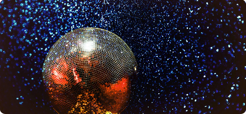 A silver party disco ball hanging from top with a blue background