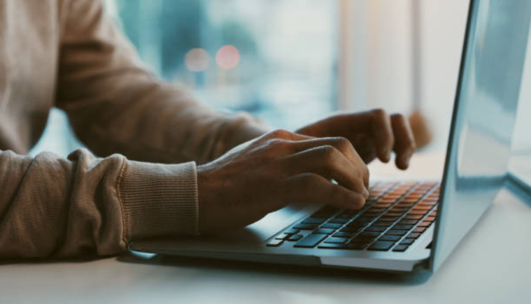 A man typing on a laptop computer.