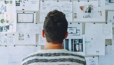 A person watching different types of papers that are stick to the wall