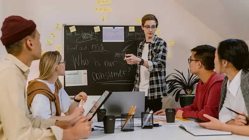 A man giving a presentation to four people