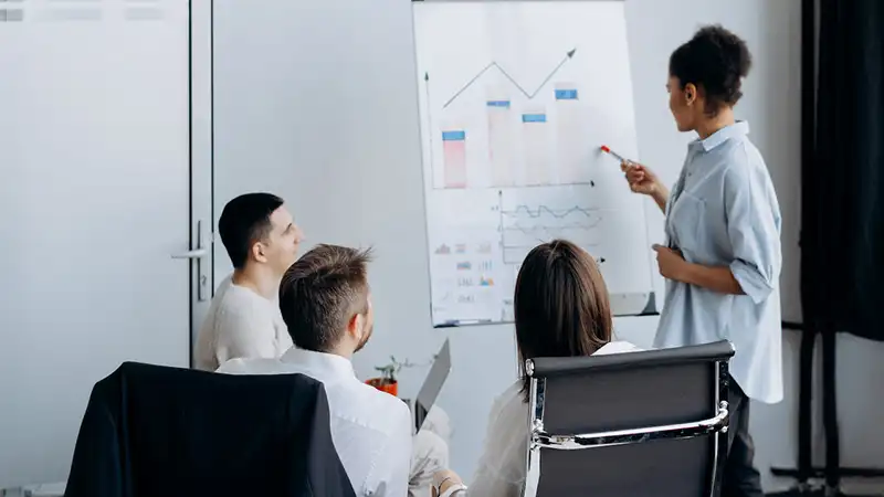 A woman giving a presentation in front of three people