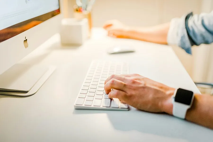 A person typing on a computer keyboard