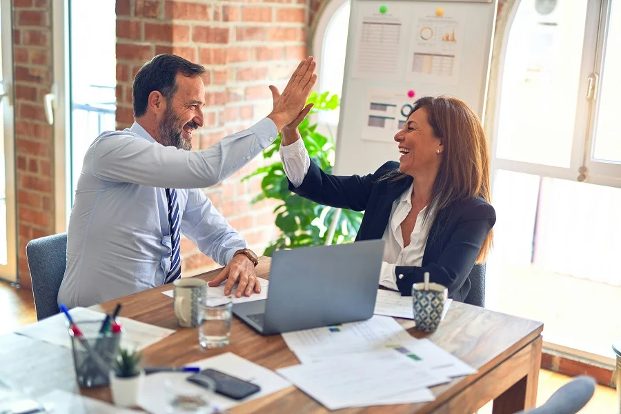 A person and person giving each other a high five