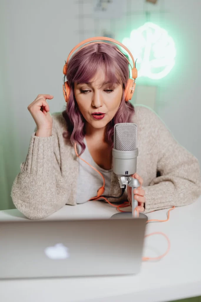 A person wearing headphones and looking at a microphone