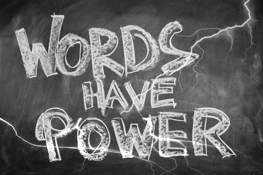 A chalkboard with WORDS HAVE POWER written on it and lightning