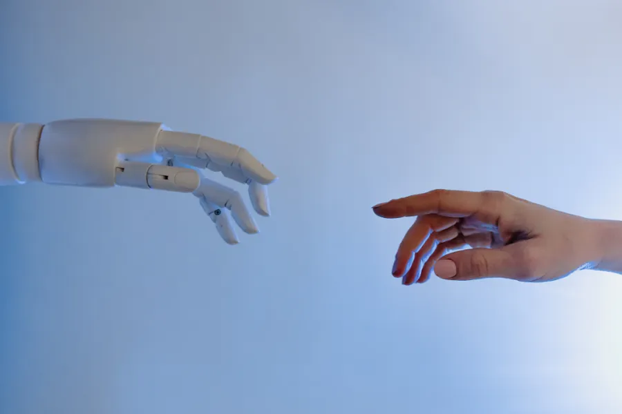 A hand of a human and hand of a robot reaching each other
