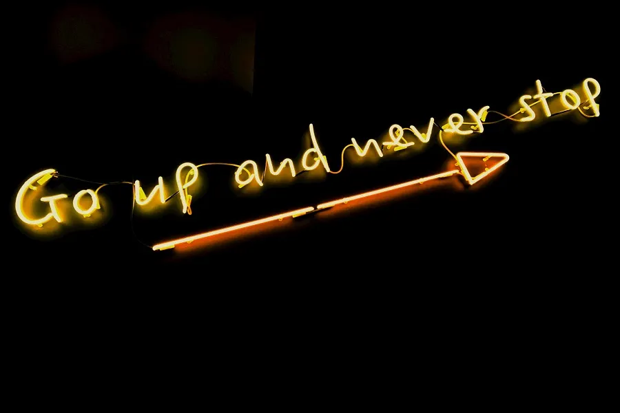 Go up and never stop text written in yellow color on a black background image