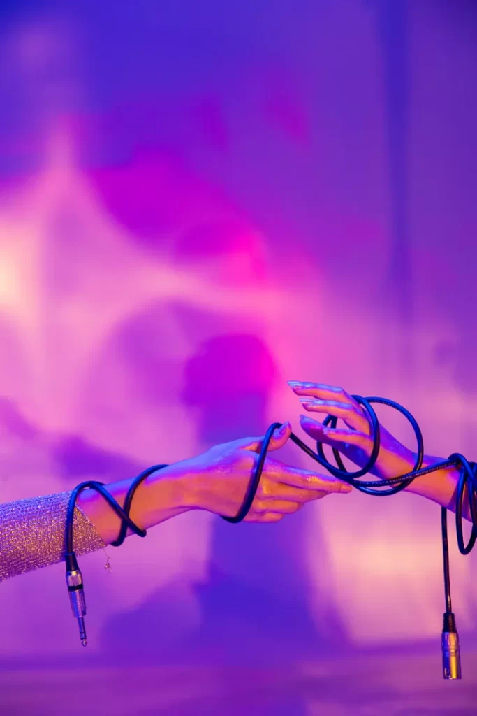 Hands clasping a cord in front of a radiant purple light