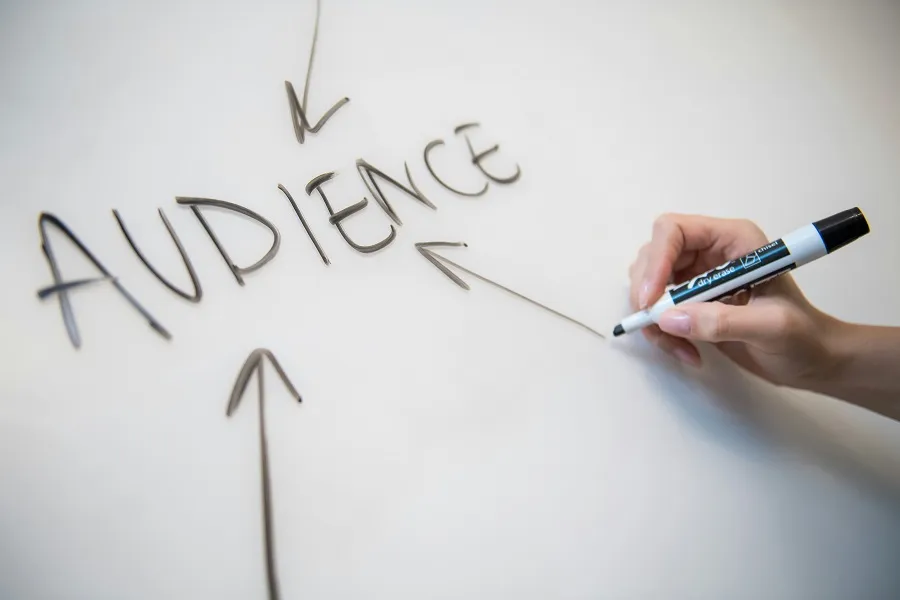 AUDIENCE written on a whiteboard with black marker pen