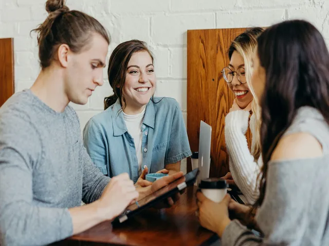 Four people talking with each other at a digital marketing agency for small businesses